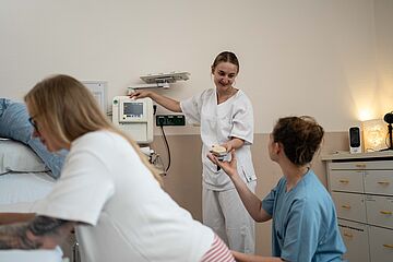Ärztin und Hebamme mit Schwangerer während Geburt