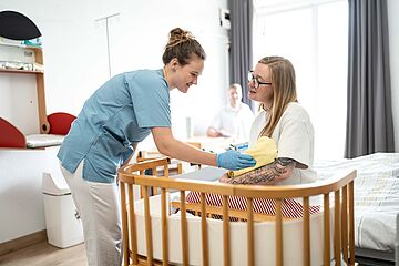 Hebamme, Mutter und Baby im Familienzimmer